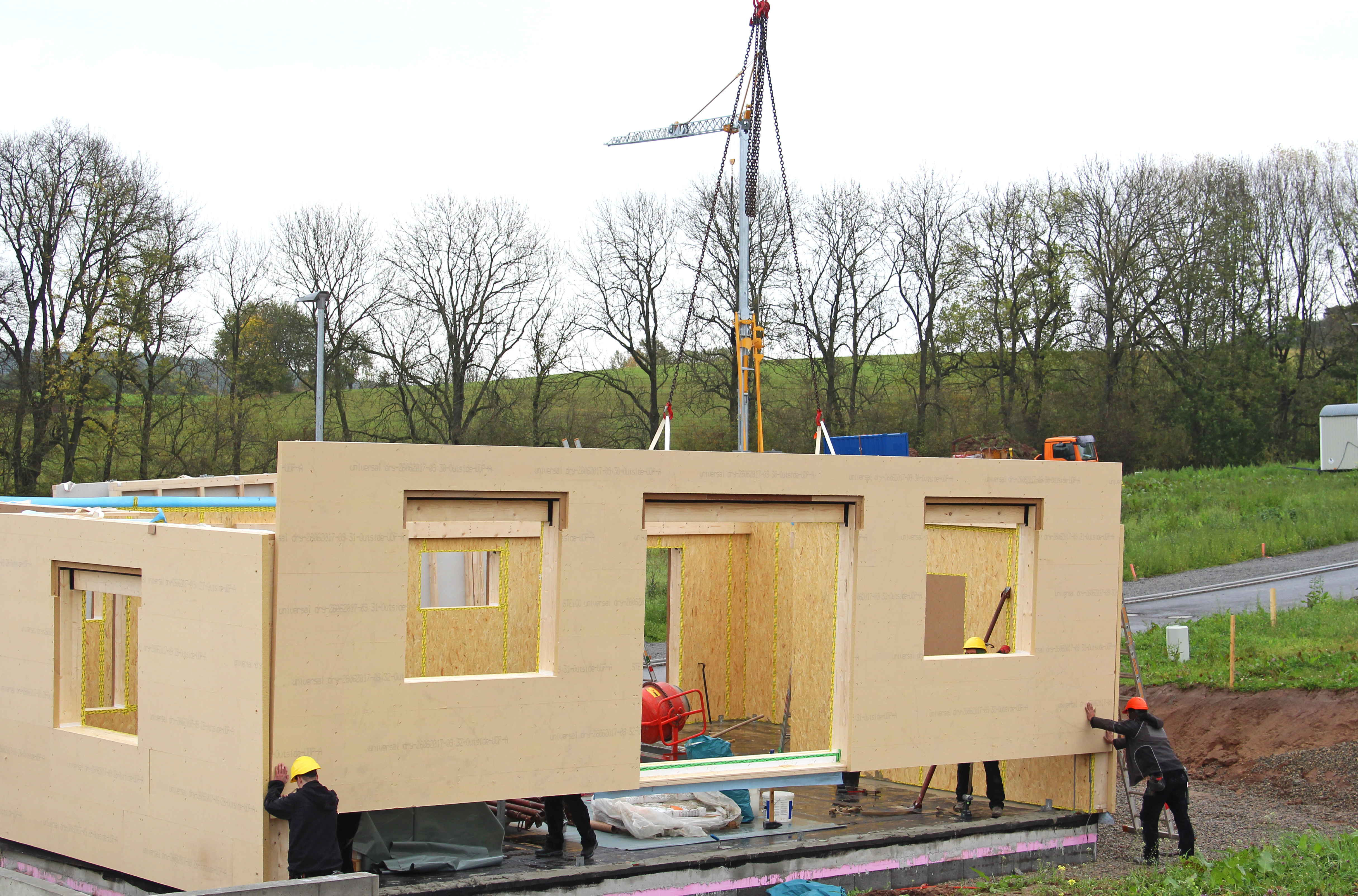 A construction team assembles a panelised prefab home