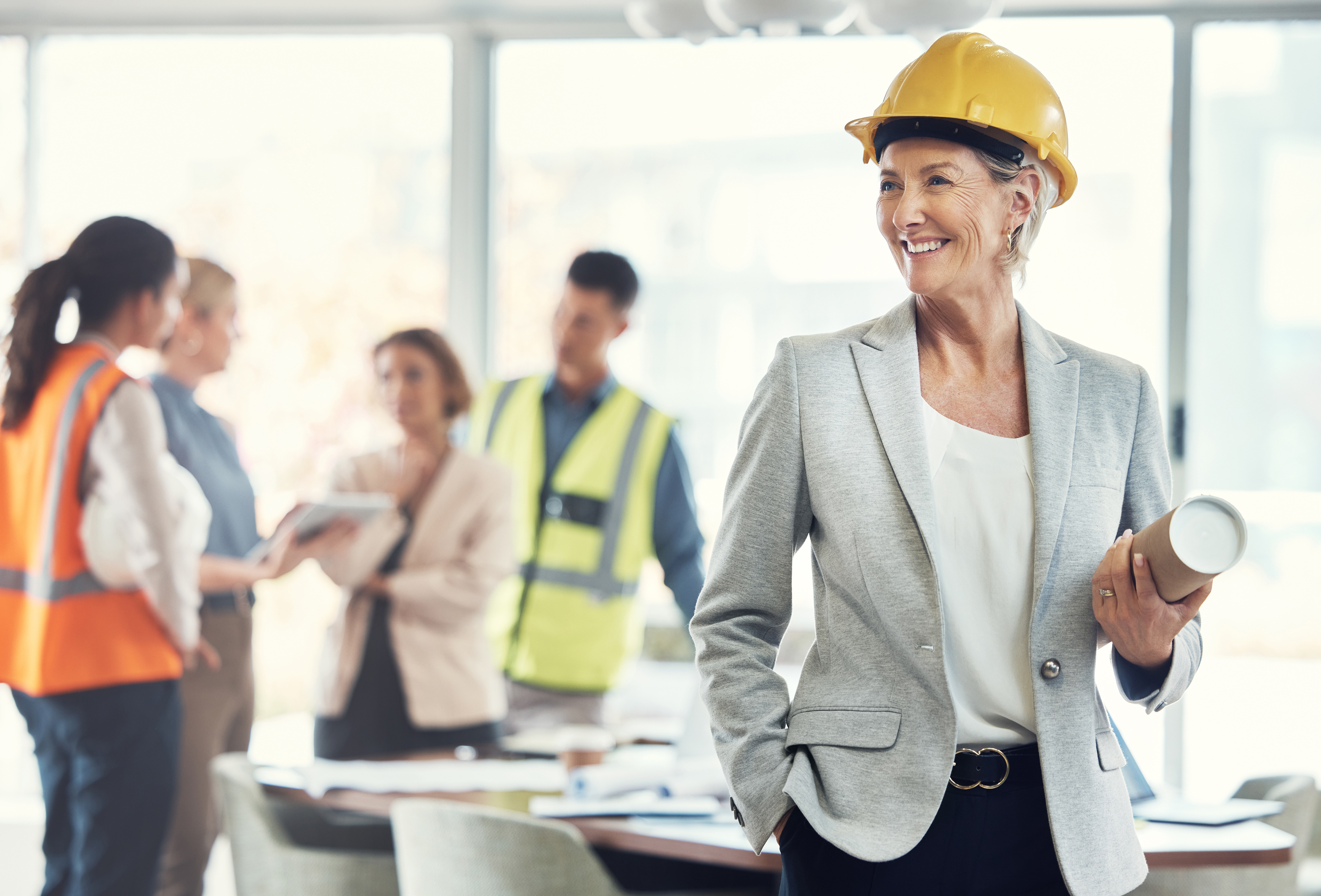 Female construction worker smiles in front of her colleagues